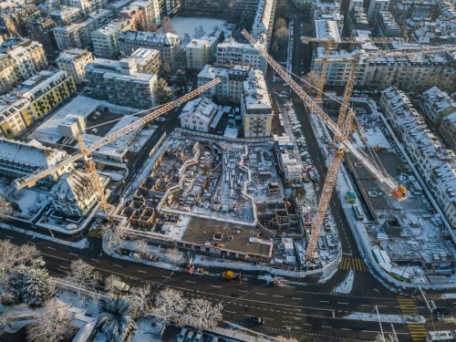 stock-photo-aerial-view-of-construction-site-with-crane-in-winter-time-snow-covered-roofs-1308989563